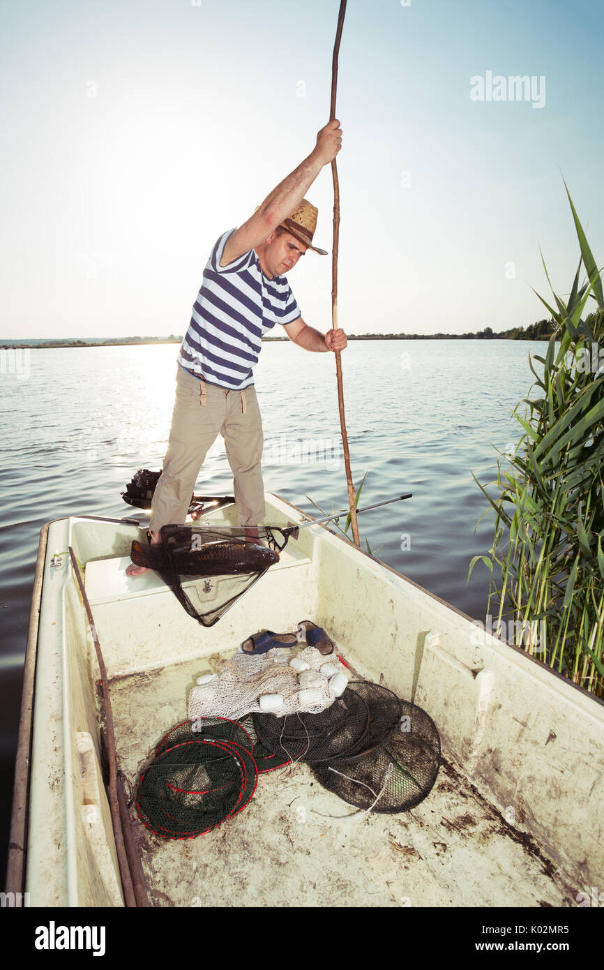 Fischer druck Boot vom Fluss Stockfoto