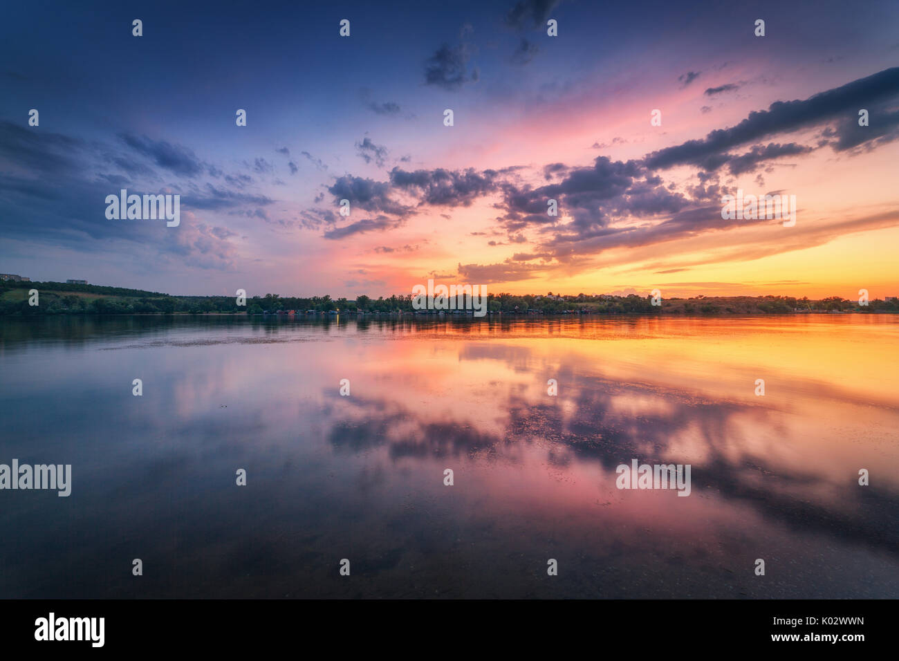 Schöne Szene mit Fluss und bunten Himmel mit Wolken bei Sonnenuntergang. Fantastische Landschaft mit See, blauer Himmel mit bunten Wolken im Wasser spiegelt ein Stockfoto