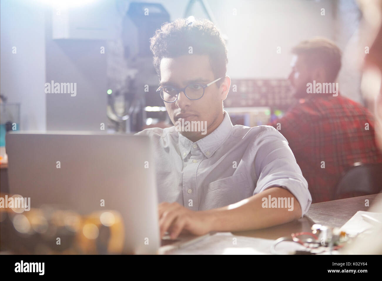 Ernst, konzentrierte sich jungen männlichen Designer am Laptop arbeiten in der Werkstatt Stockfoto