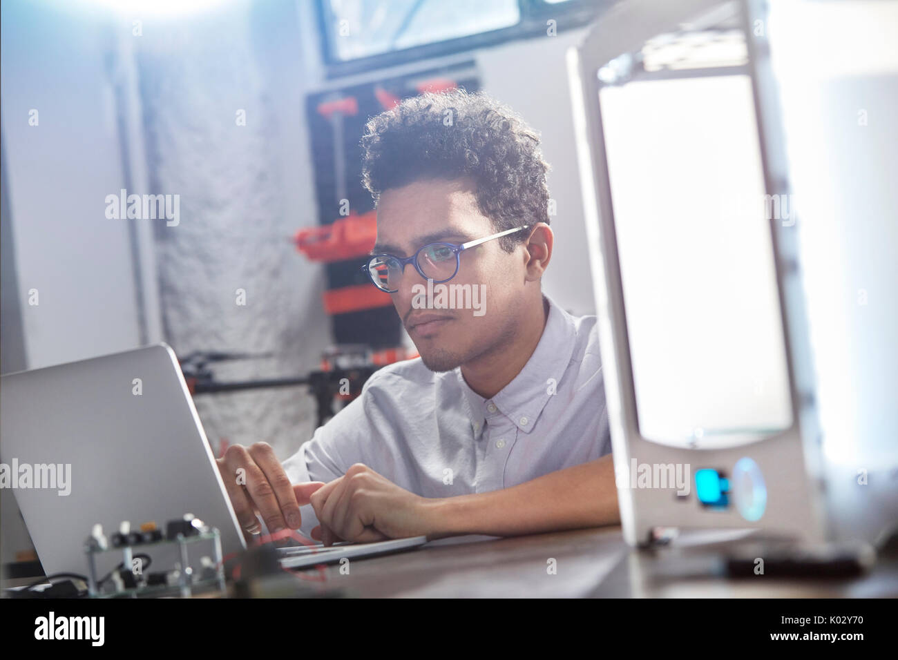 Junge männliche Designer mit Laptop gerichtet Stockfoto