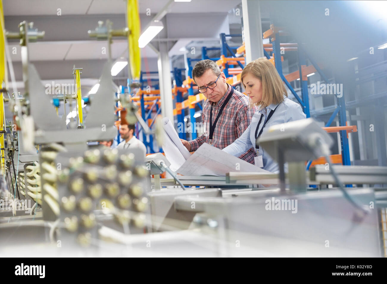 Supervisor und Ingenieur über Pläne in der Faseroptik Factory Stockfoto