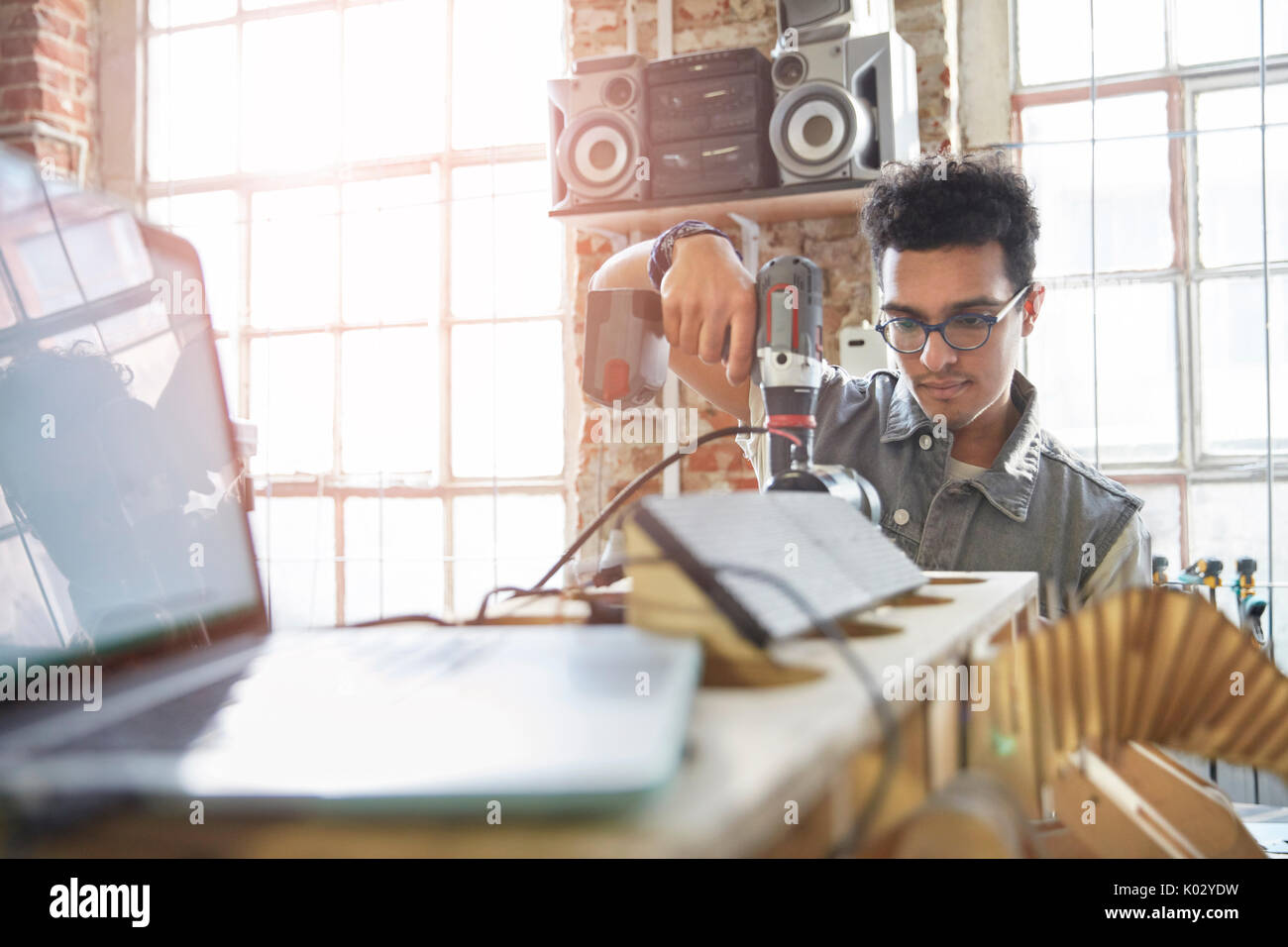 Männliche Designer über Bohrmaschine in der Werkstatt Stockfoto