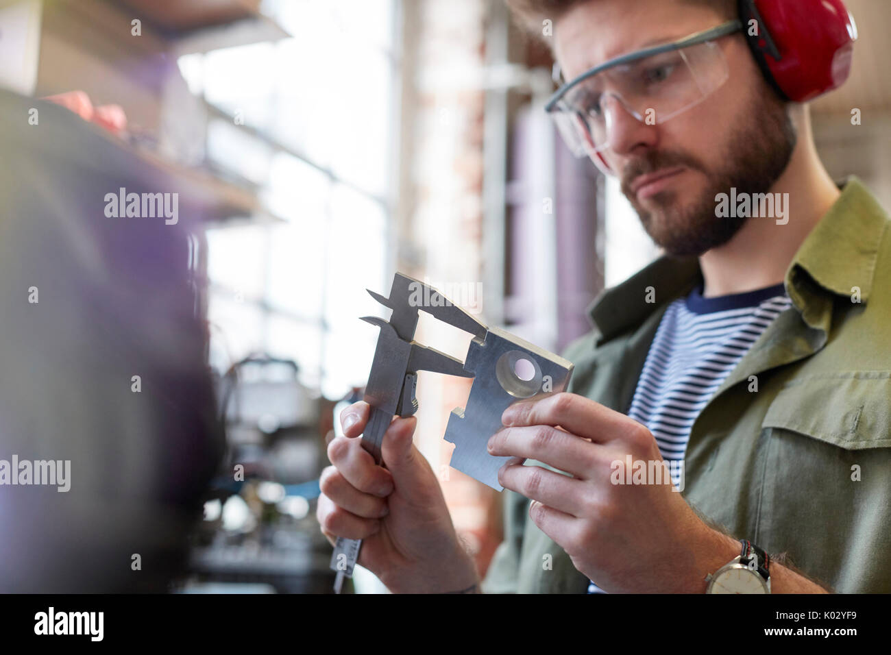 Männliche Designer über Bremssättel in Werkstatt Stockfoto