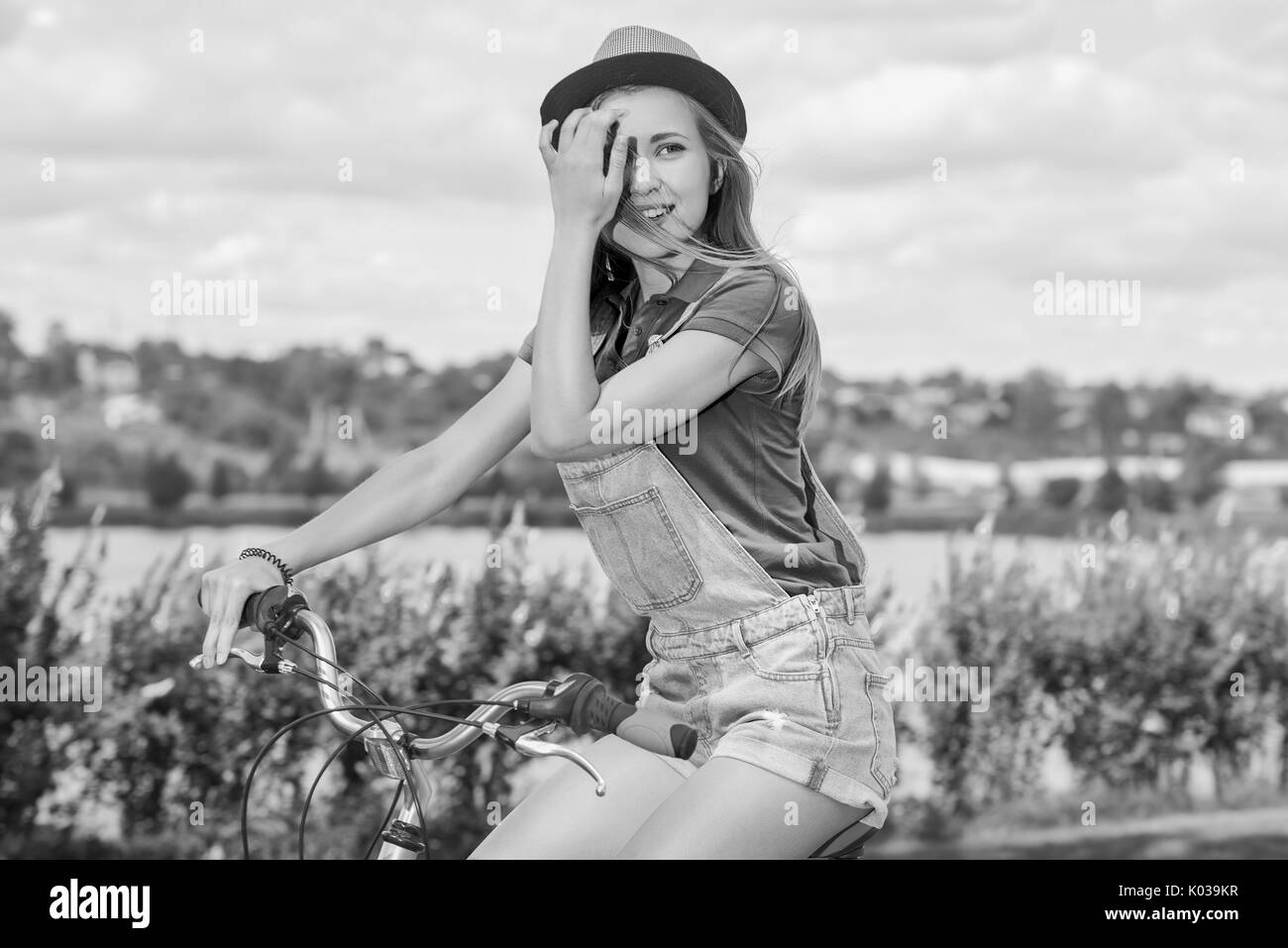 Schöne junge Frau mit ihrem Fahrrad im Park Stockfoto