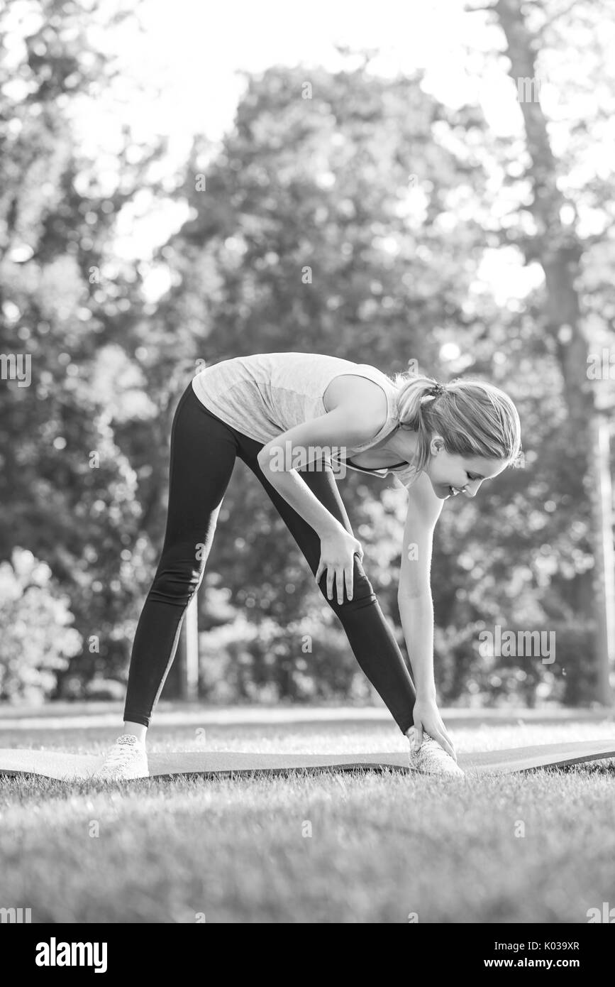 Junge Frau mit Yoga im Freien im Park Stockfoto