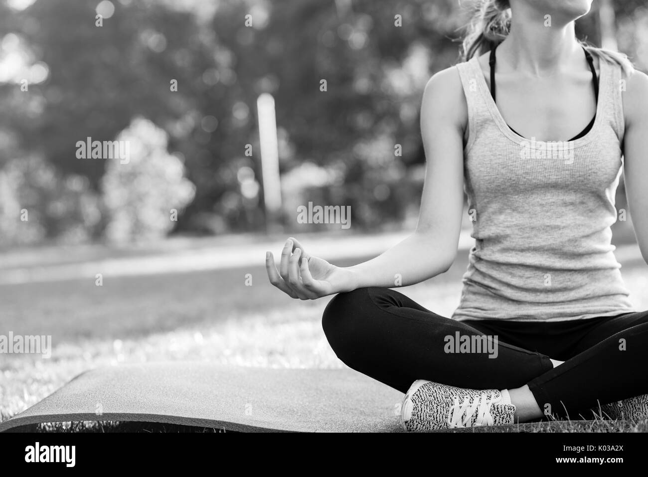 Junge Frau mit Yoga im Freien im Park Stockfoto
