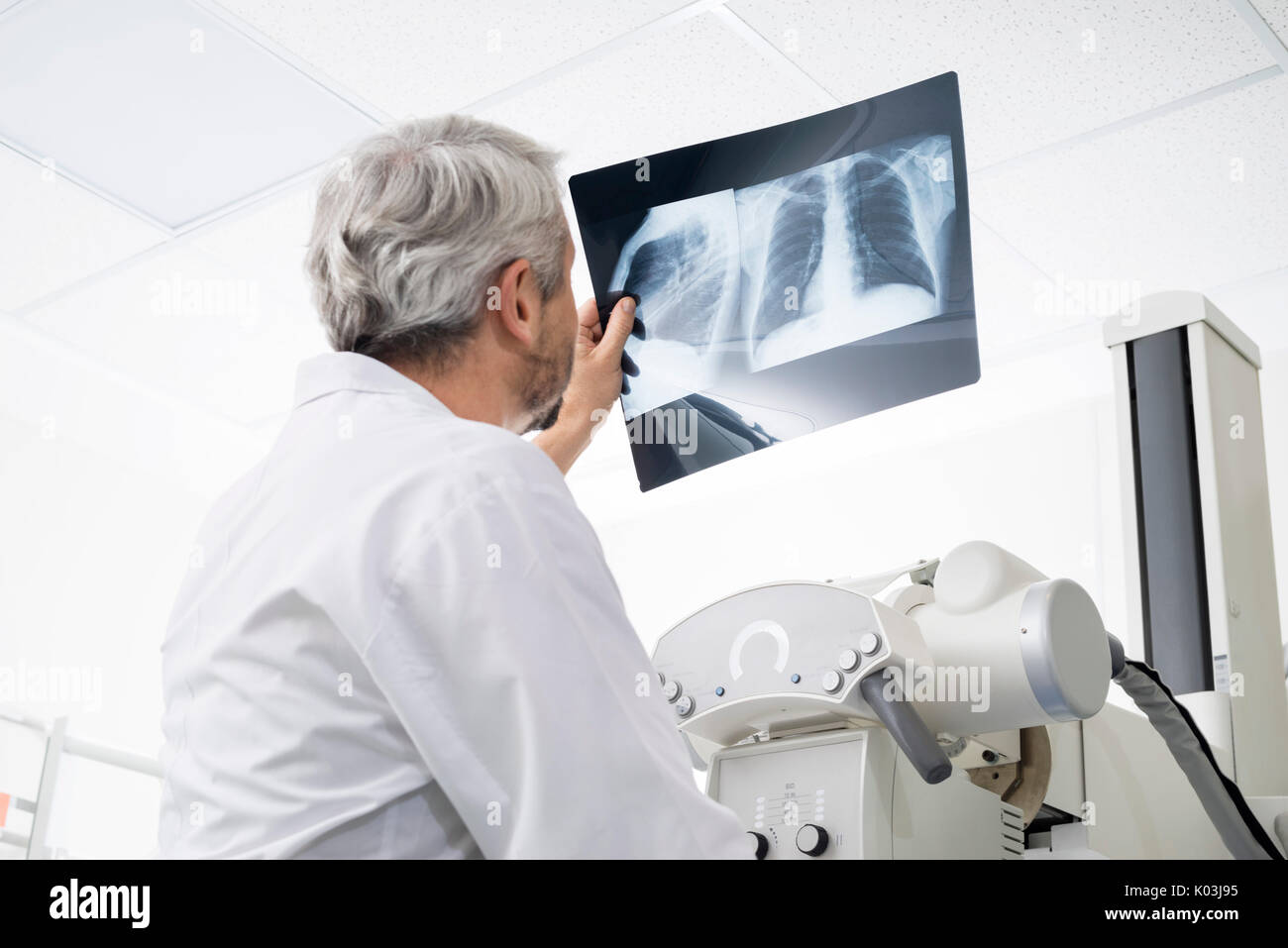 Männlicher Arzt Analyse Chest X-Ray im Untersuchungsraum Stockfoto