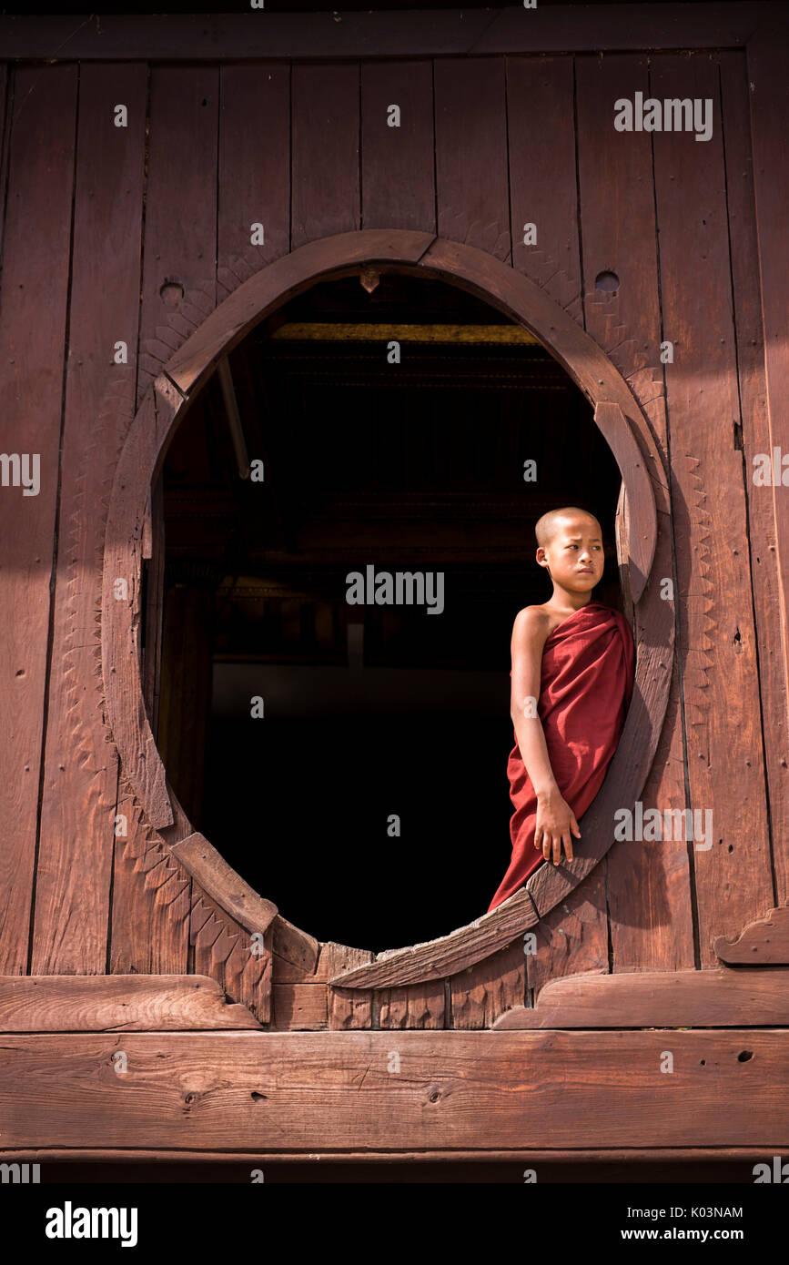 Nyaungshwe, Inle-See, Shan State in Myanmar.  Novize in Shwe Yaunghwe Kyaung durch die Fenster des Teak Ordinationshalle Stockfoto