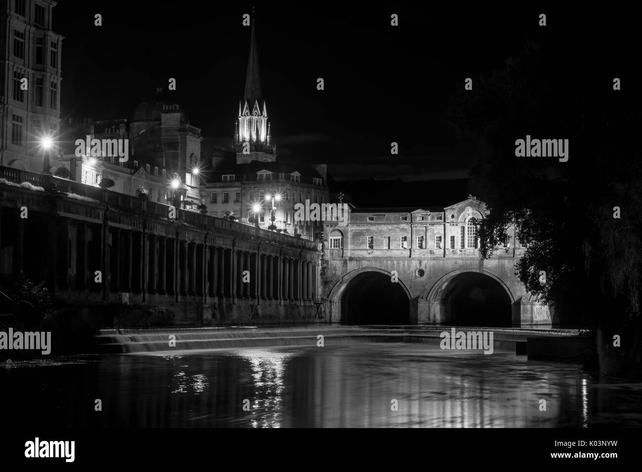 Pulteney Bridge und Wehr in der Nacht schwarz und weiß. Palladianische Brücke in Bath, Somerset, UK, mit Fluss Avon unterhalb fließt bei Nacht Stockfoto