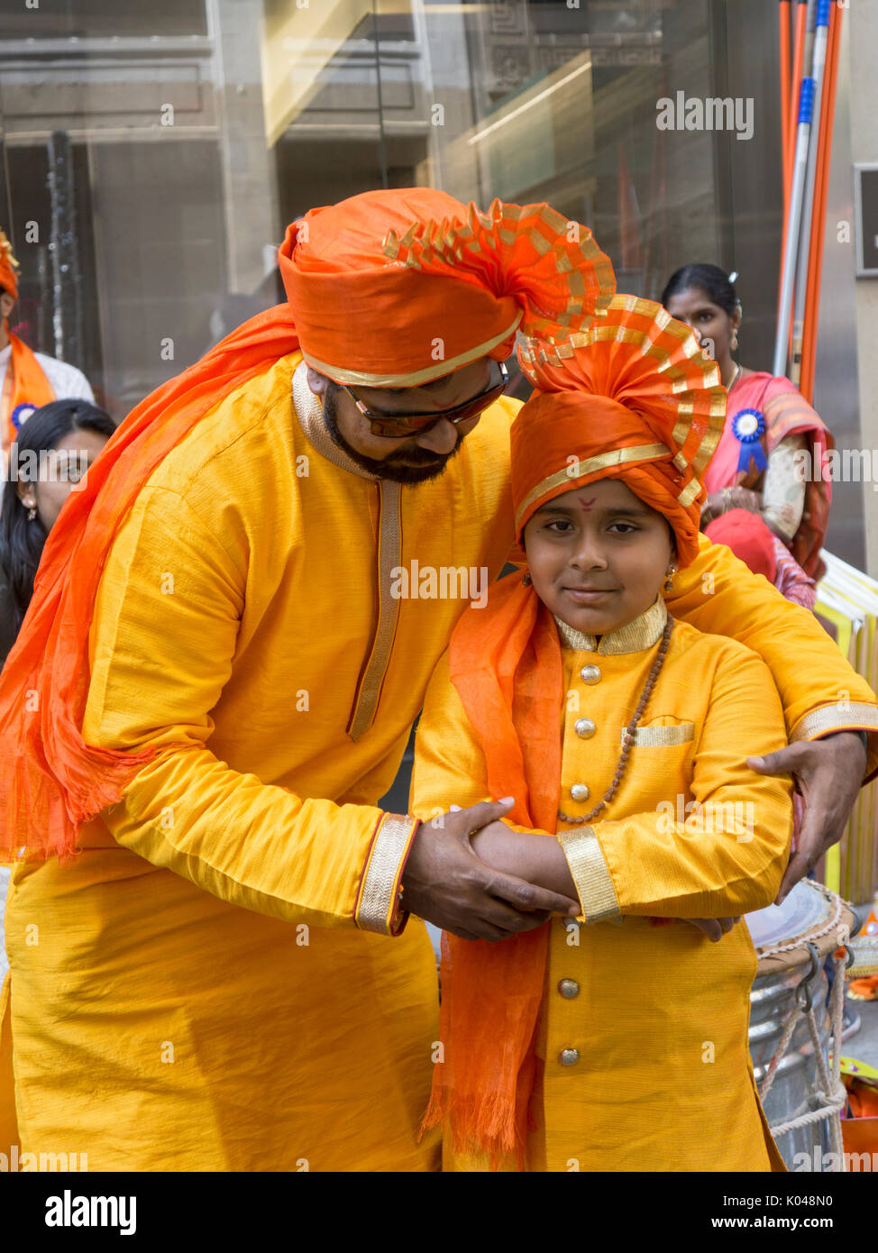 Ein Vater stellt Kostüm seines Sohnes gerade vor Beginn der Indien Day Parade 2017 in Manhattan, New York City. Stockfoto