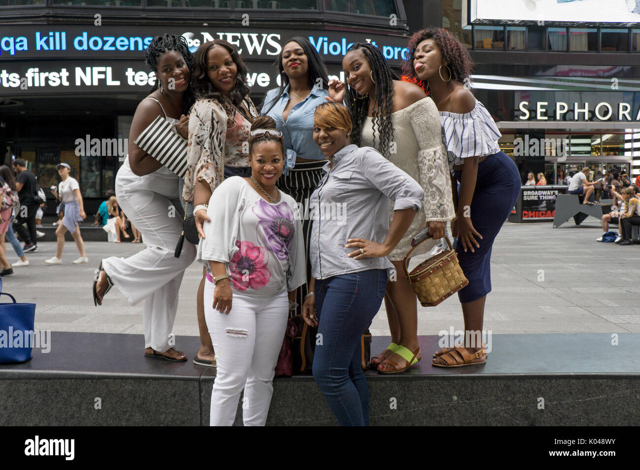 Ein Porträt von sieben Frauen aus Philadelphia mit einem Mädchen Tag im Times Square, Manhattan, New York City Stockfoto