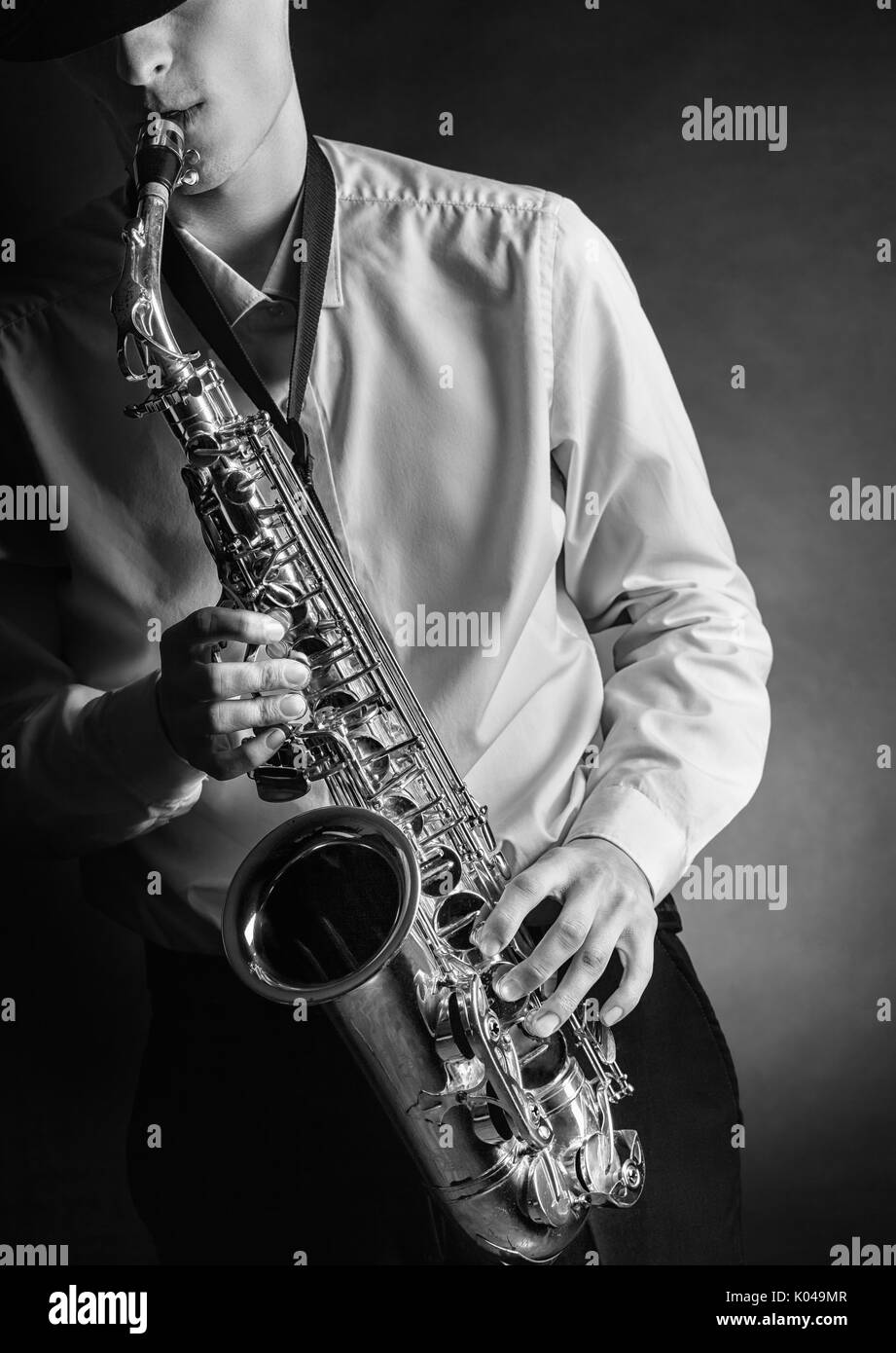 Junge männliche Schauspieler spielt Saxophon. Schwarz/Weiß-Bild Stockfoto