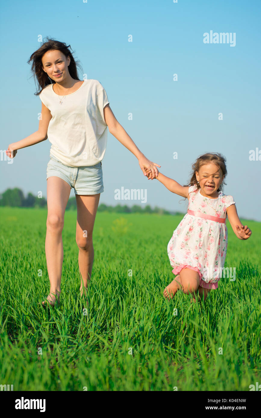 Junge Mädchen, die gerne an der grünen Weizenfeld Stockfoto