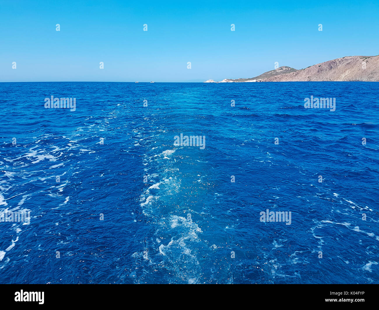 Tiefblaues Meer und Insel mit kleinen Büschen von der Rückseite der ein Boot mit Schaumstoffen anzeigen Stockfoto