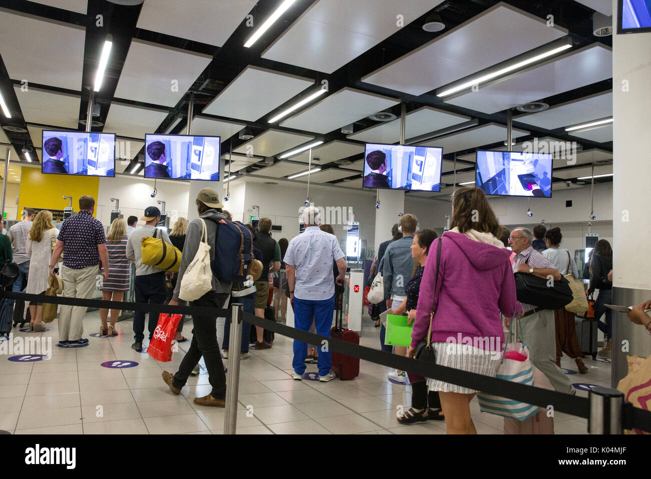 Die Menschen an der britischen Grenze auf dem Flughafen Gatwick wartete durch den Epass Tore zu gehen Pass details zu überprüfen. Das System verwendet die Iriserkennung. Stockfoto