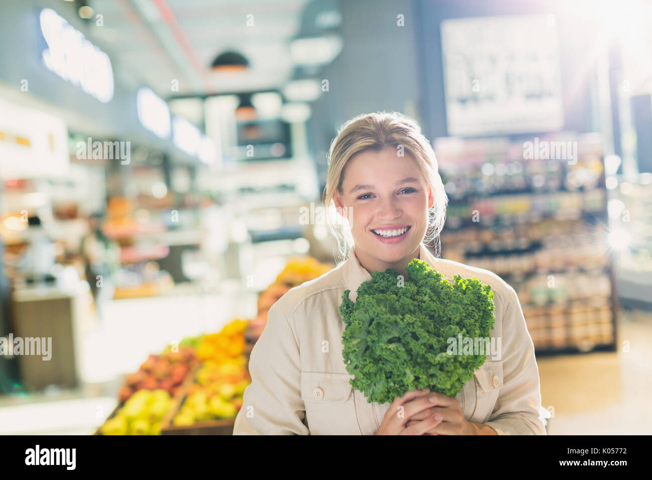 Portrait lächelnde junge Frau mit Bündel von Kale in Lebensmittelgeschäft Markt Stockfoto