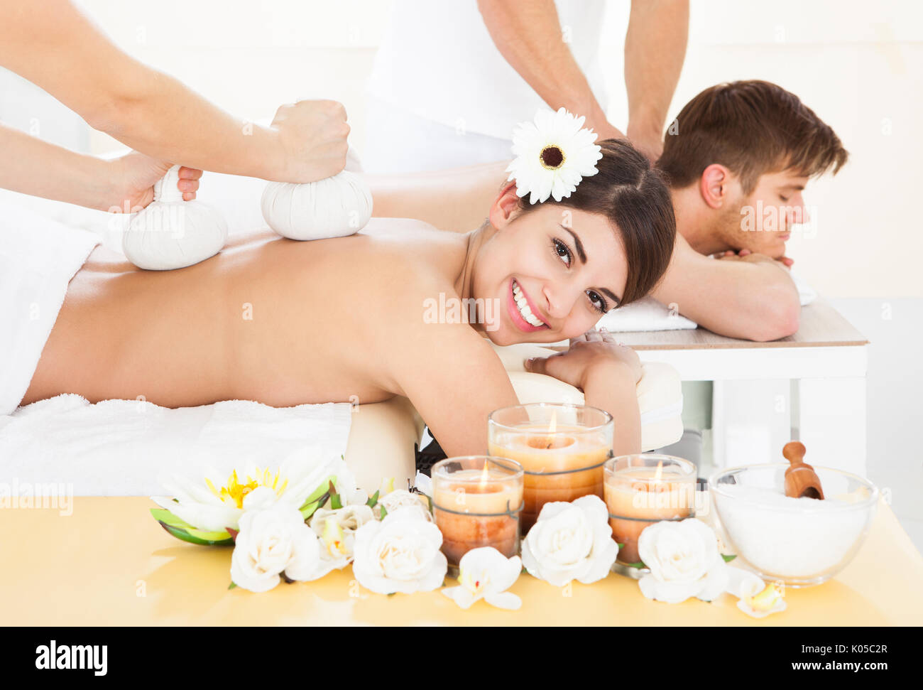 Porträt der glückliche Frau empfangen Massage mit Kräuter-Kompresse Stempel auf Rückseite im spa Stockfoto
