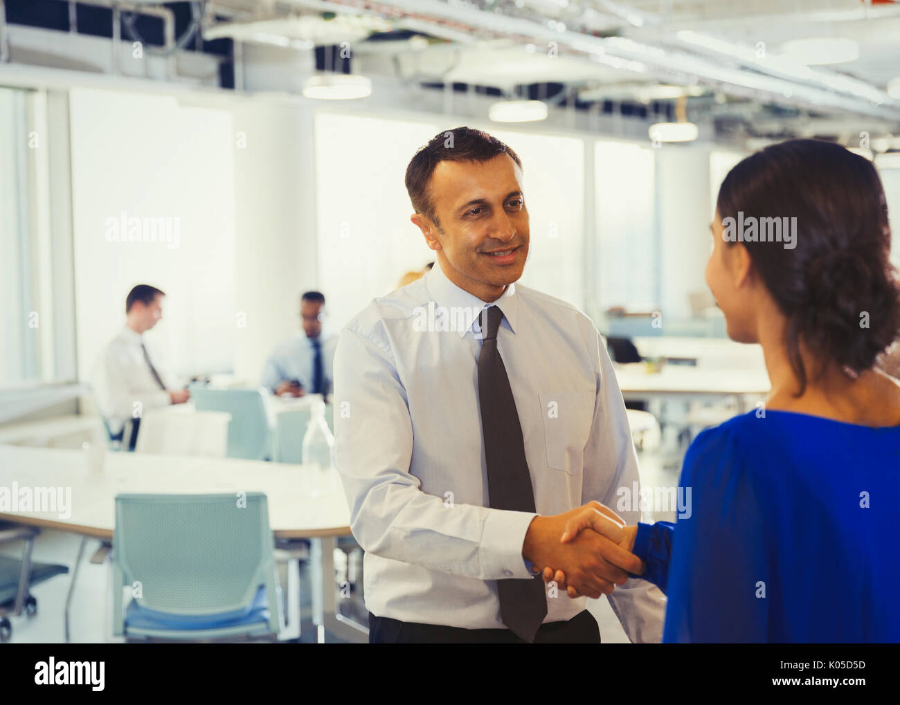 Geschäftsmann Händeschütteln mit Geschäftsfrau im Büro Stockfoto