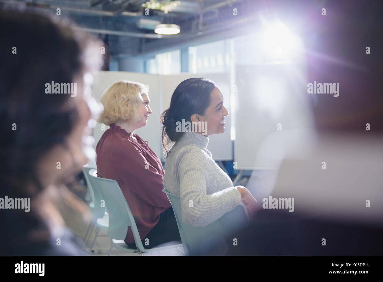 Lächelnde Geschäftsfrauen in Konferenz Publikum hören Stockfoto