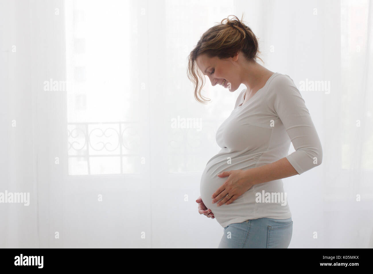 Schwangere Frau Bauch berühren auf weißem Hintergrund Stockfoto