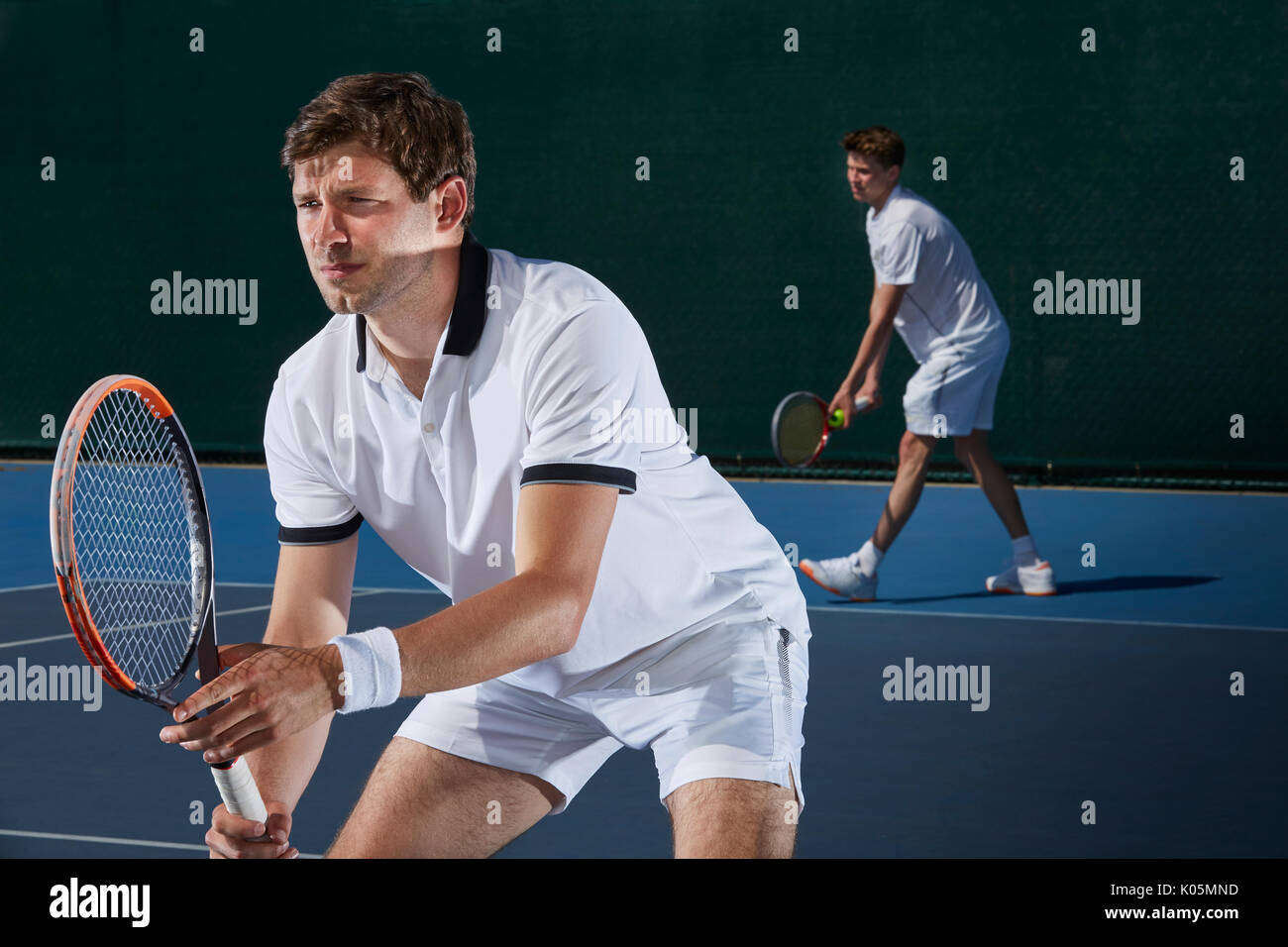 Fokussierte männliche Tennis Doubles Spieler Tennis spielen auf Tennisplatz Stockfoto