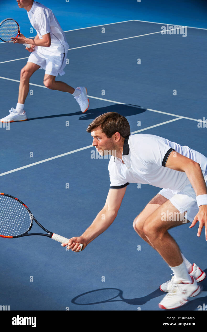 Entschlossene junge Mann Tennis Doubles Spieler mit Tennisschläger auf Tennisplatz balanciert Stockfoto