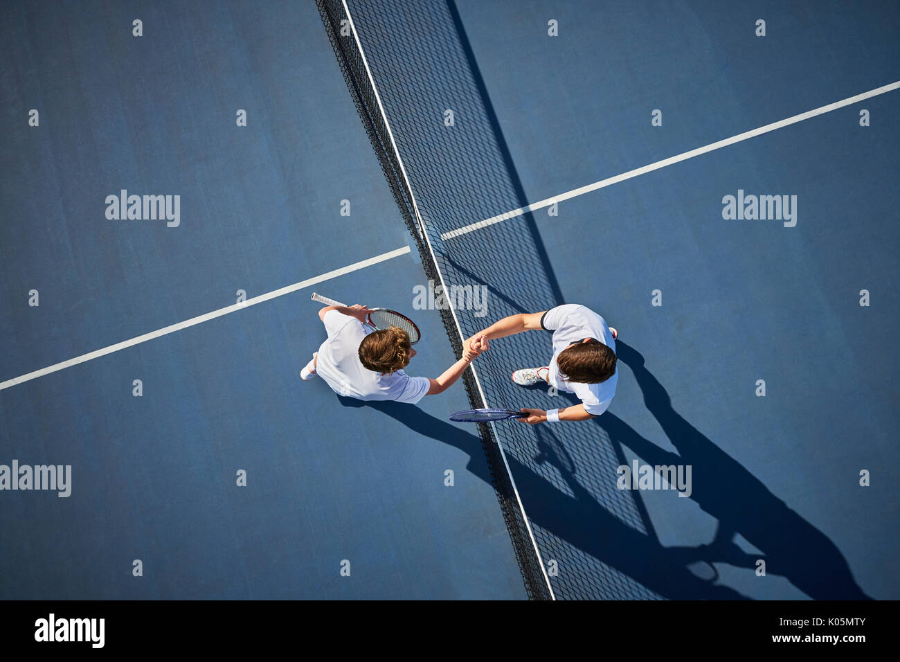 Ansicht von oben jungen männlichen Tennisspieler handshaking im Net auf sonnigen blauen Tennisplatz Stockfoto