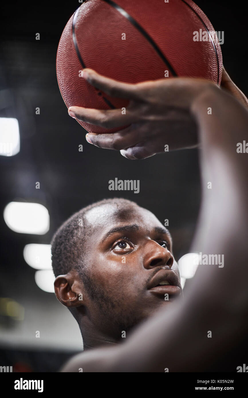 Close up junge männliche Basketball Spieler schießt den Ball konzentriert Stockfoto
