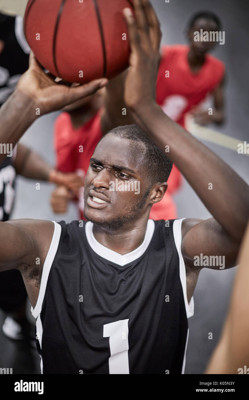 Schwerpunkt junge männliche Basketball Spieler schießt den Ball Stockfoto