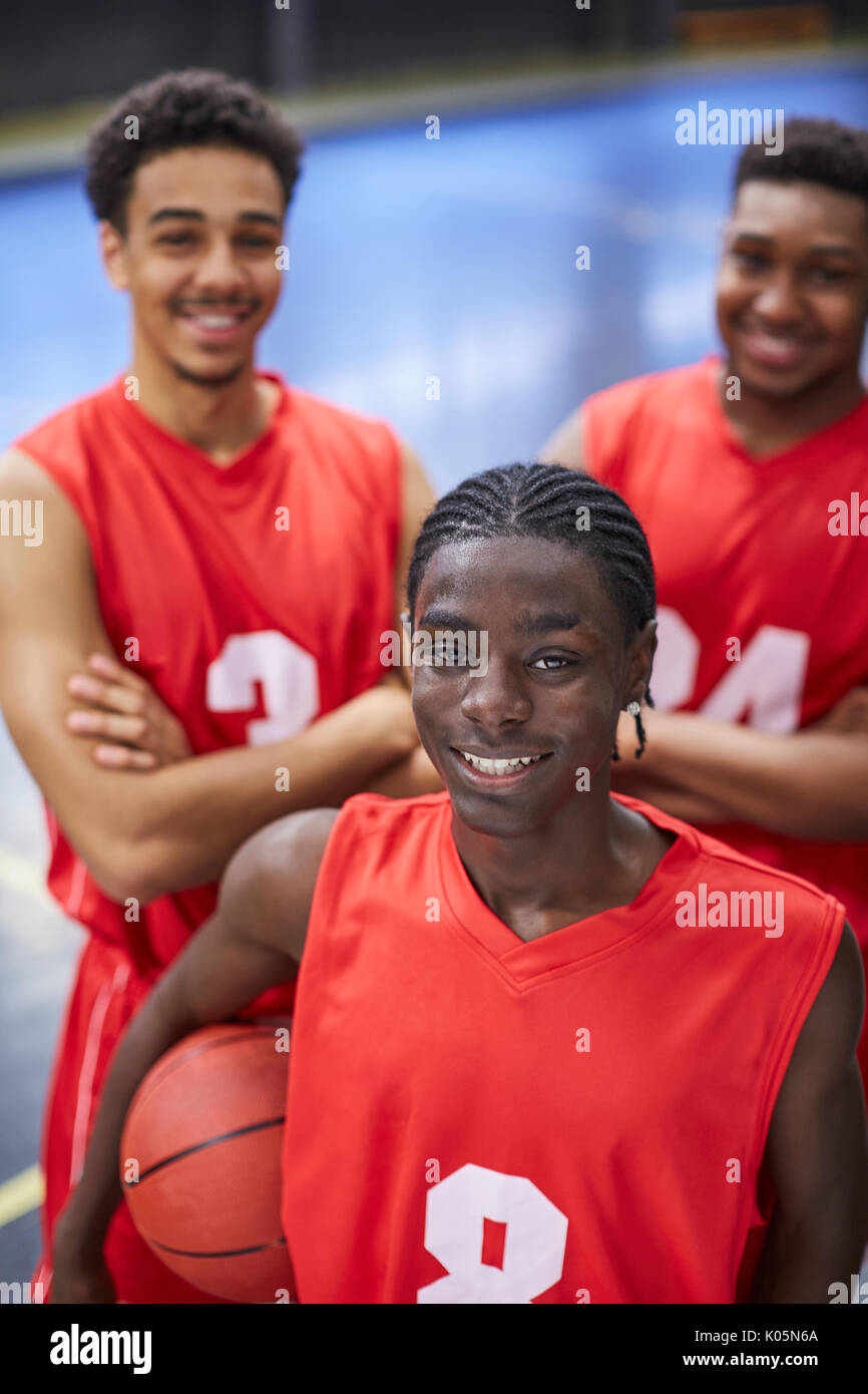 Porträt Lächeln, selbstbewusste junge männliche Basketball player Team in roten Trikots Stockfoto