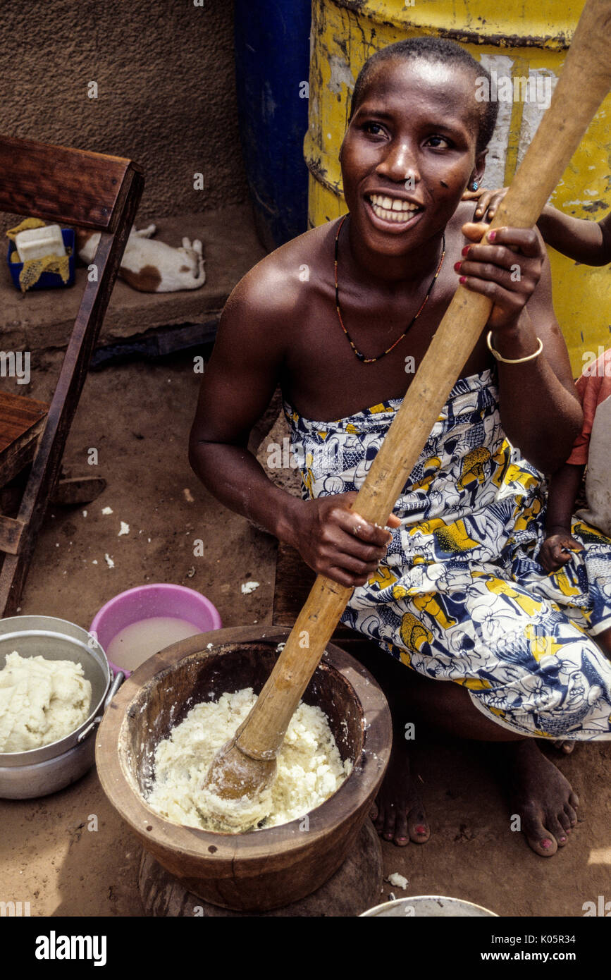 Côte d'Ivoire, Elfenbeinküste, Westafrika. Junge Frau stampfenden Süßkartoffeln für die nächste Mahlzeit. Lolobo Dorf in der Nähe von Bouaké. Stockfoto