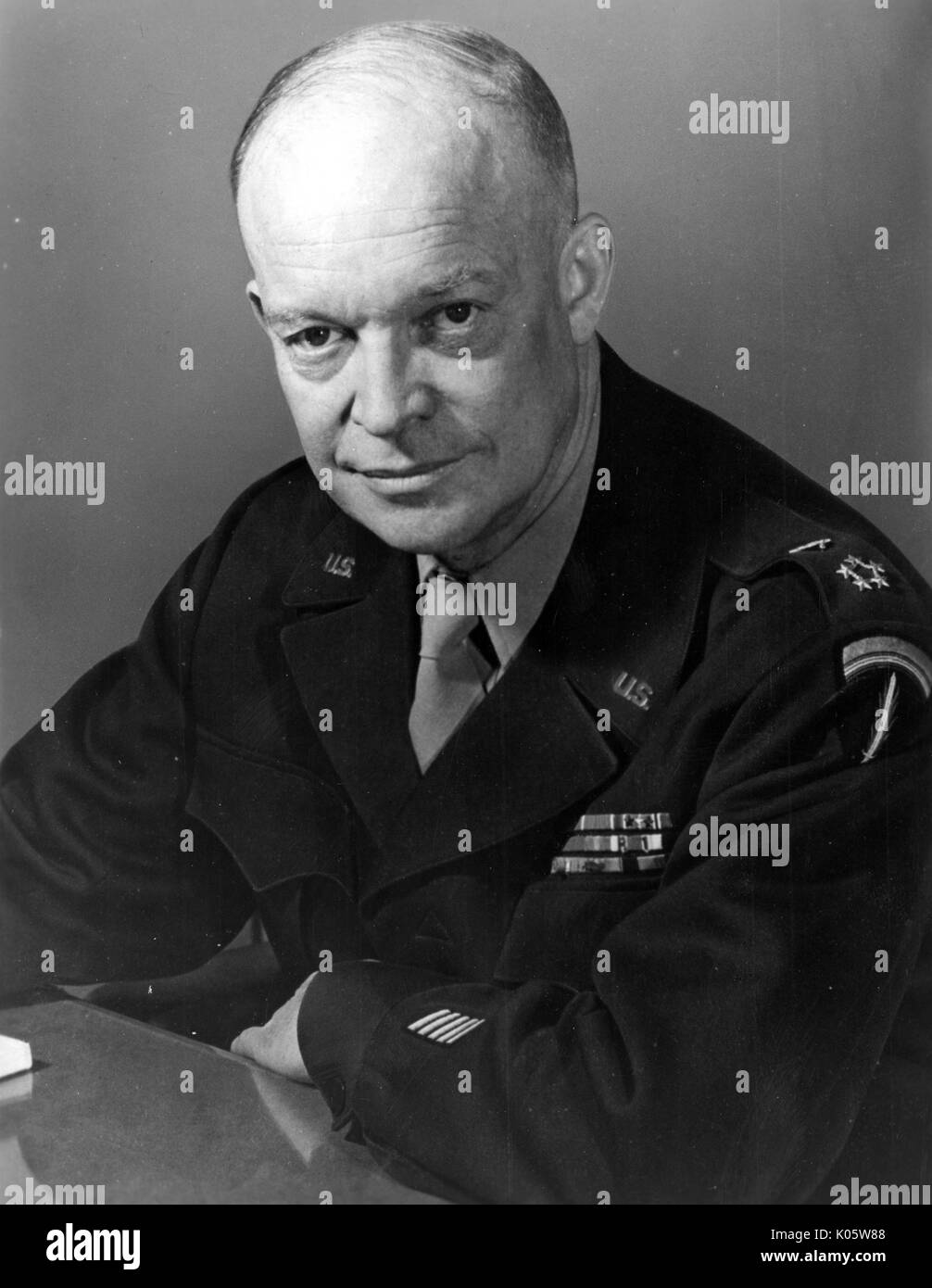Brustbild von Dwight Eisenhower, mit den Armen stützte sich auf einen Tisch sitzt, mit einem ernsten Gesichtsausdruck, mit schwarzen militärischen Shirt, 1945. Stockfoto