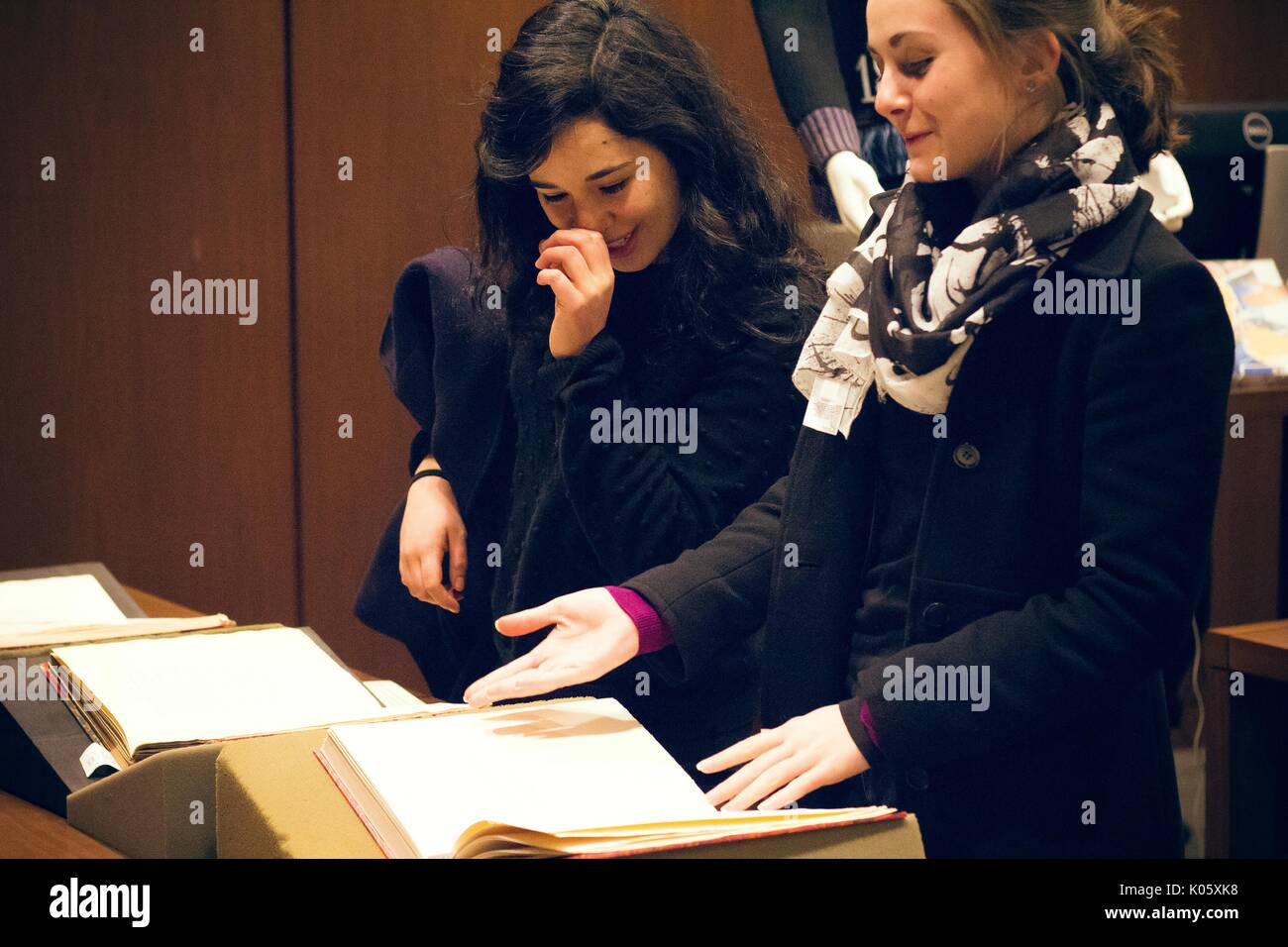 Zwei College Girls beobachten eine Sammlung von 'dirty', erotische, seltene Bücher in den Sondersammlungen Abteilung der Johns Hopkins Universität Sheridan Bibliotheken, eine an ein offenes Buch zeigt, die anderen lachen, 2016. Stockfoto