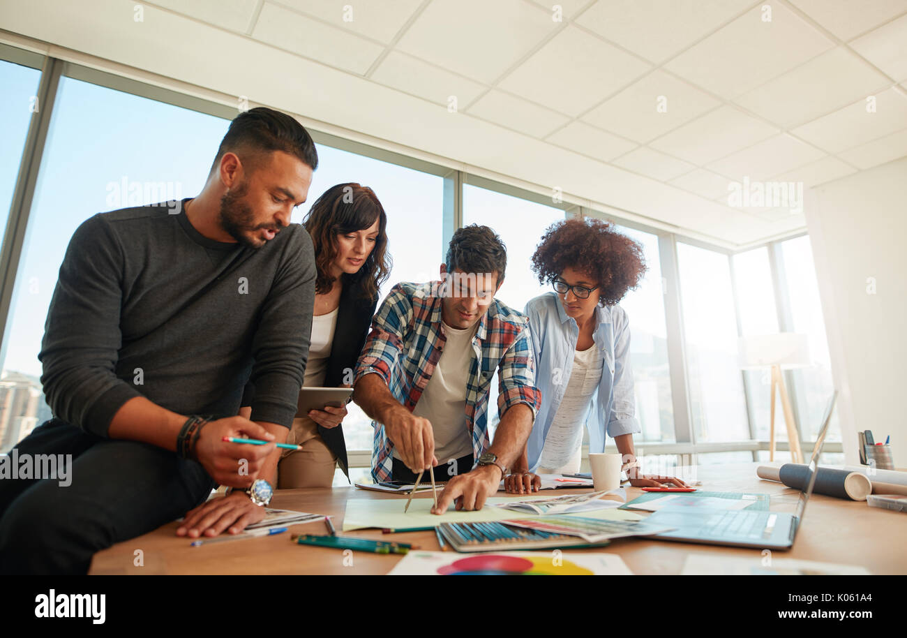 Gruppe von Jugendlichen zusammen auf kreative Projekt im Amt. Designer arbeiten Erstellen Werbekampagne im modernen Büro. Stockfoto