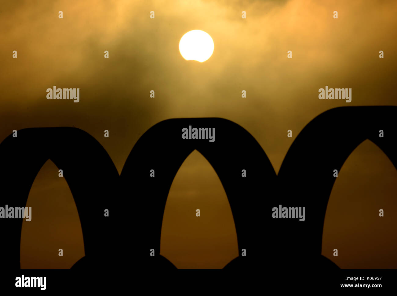 Partielle Sonnenfinsternis gesehen kurz durch trübe Wolken über die Silhouette der Olympischen Ringe, Portland, Dorset, UK Credit: Finnbarr Webster/Alamy leben Nachrichten Stockfoto