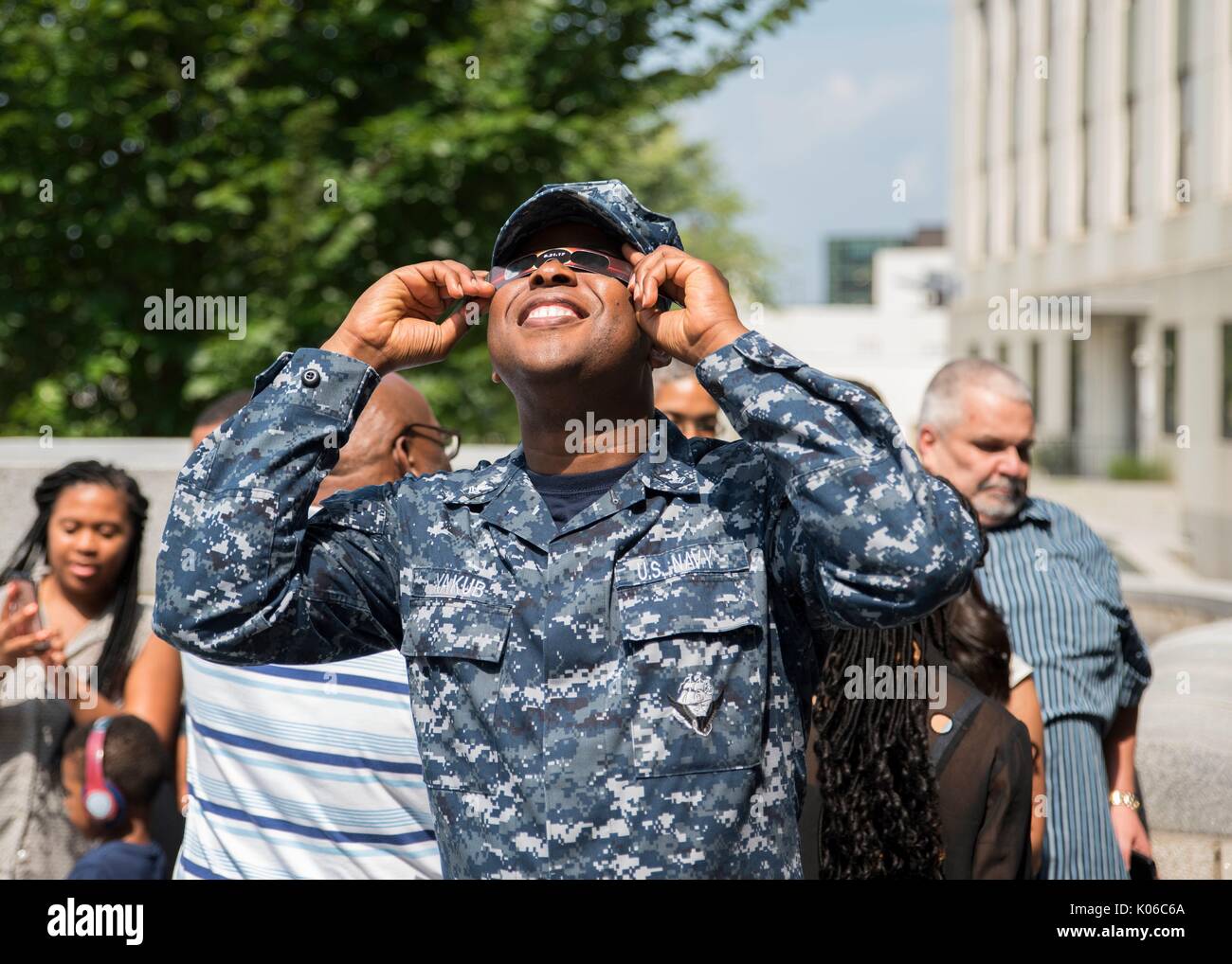 Bethesda, Vereinigten Staaten von Amerika. 21 Aug, 2017. U.S. Navy Hospital Corpsman 2. Klasse Munzil Yakub lächelt als er beobachtet die partielle Sonnenfinsternis am Naval Support Activity Bethesda August 21, 2017 in Bethesda, Maryland. Die totale Sonnenfinsternis über einem schmalen Teil des angrenzenden Vereinigten Staaten von Oregon nach South Carolina und eine partielle Sonnenfinsternis war über den gesamten nordamerikanischen Kontinent sichtbar zusammen mit Teilen von Südamerika, Afrika und Europa. Credit: Planetpix/Alamy leben Nachrichten Stockfoto