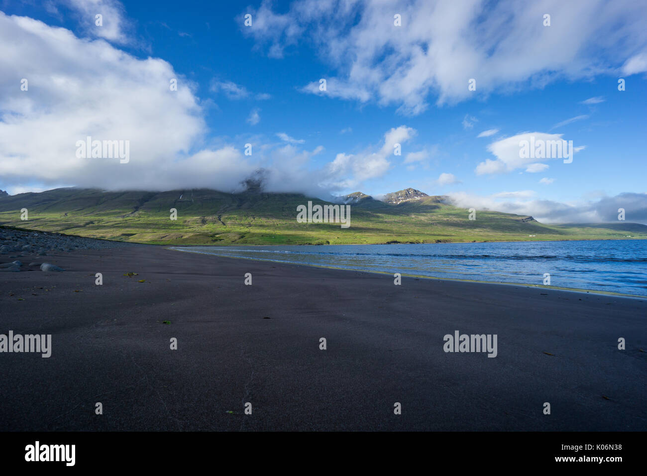 Island - einsame schwarze Strand neben der grünen Berge an der Küste Stockfoto