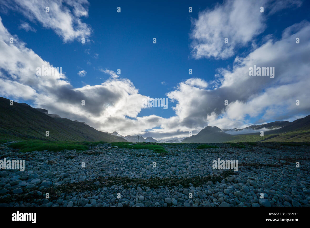 Island - Blue Sky in der Morgendämmerung über grüne vulkanische Schneebedeckte Berge Stockfoto