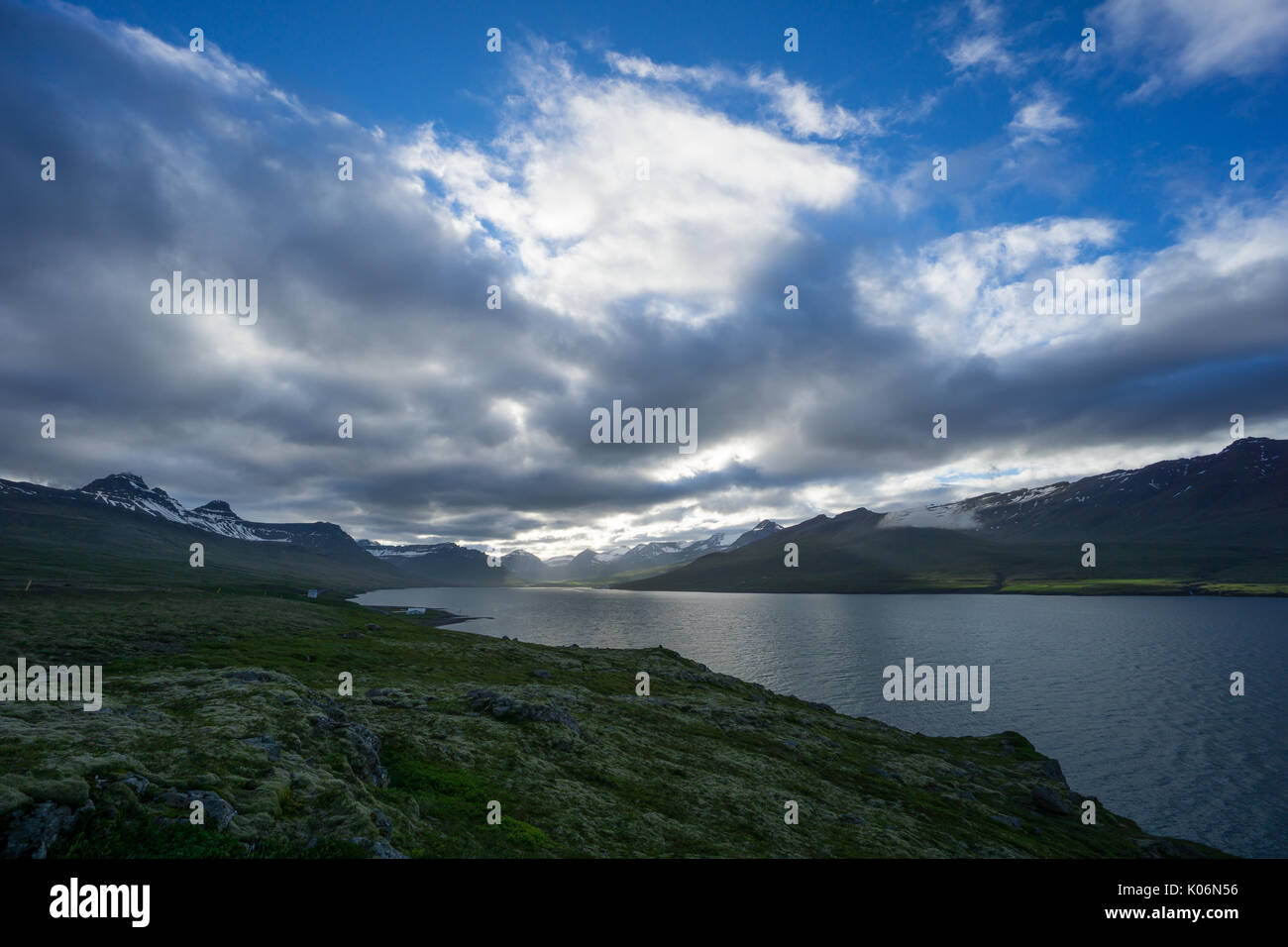 Island - Magische Atmosphäre am Fjord von schneebedeckten Bergen umgeben Stockfoto