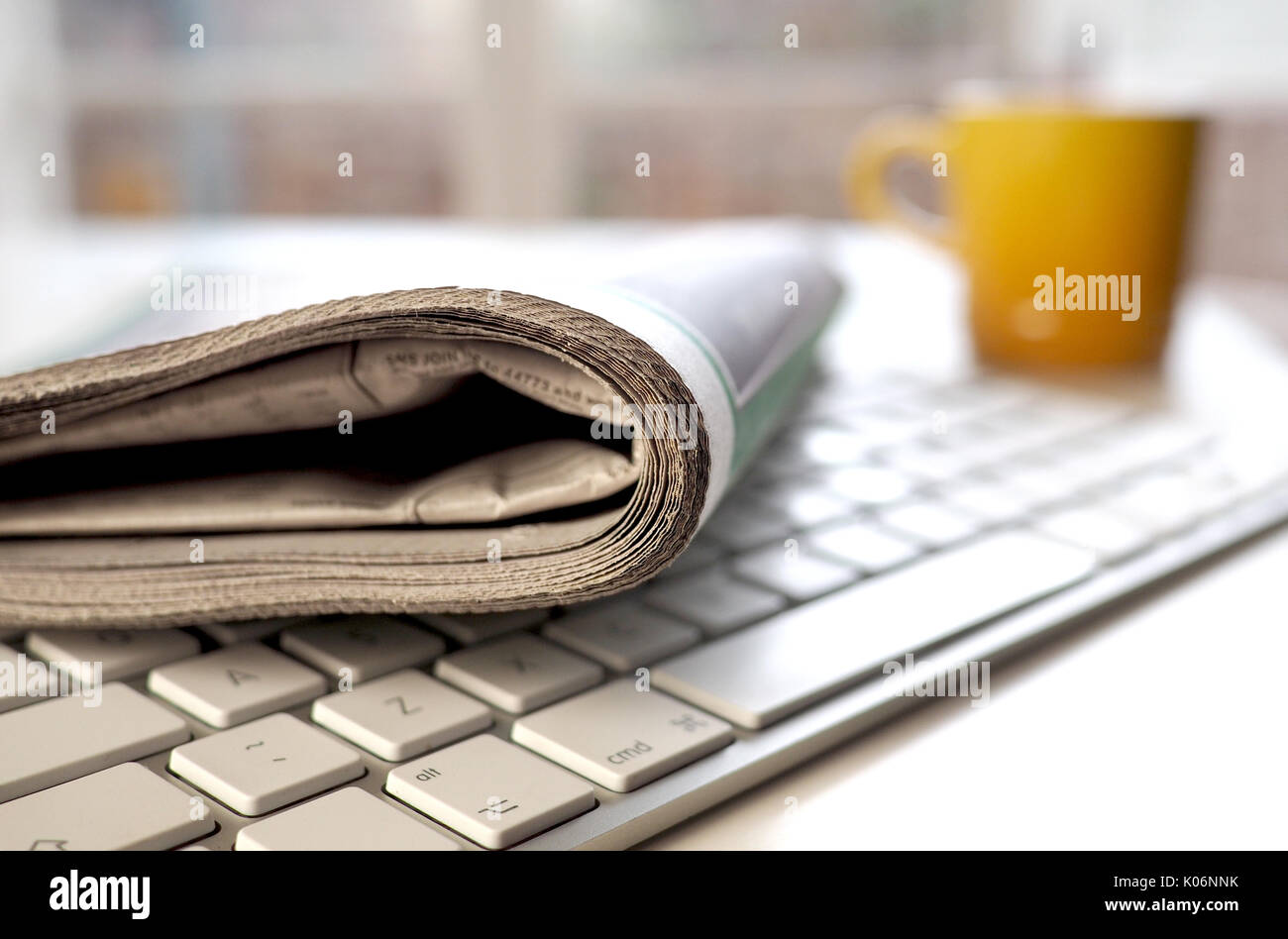 Zeitung mit Tasse Kaffee auf der Tastatur Stockfoto