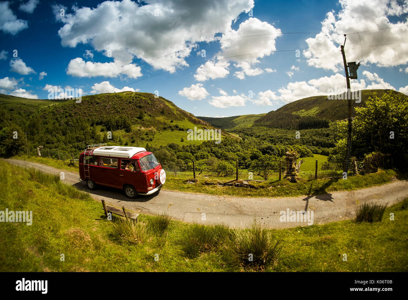 Sommer im Wye Valley: eine Frau mittleren Alters fahren Ihre klassische 1973 VW Typ 2 (T2) Erker roten Wohnmobil Urlaub entlang der malerischen Wye Valley in der Mitte von Wales an einem heißen Juli morgen. Powys Wales UK Stockfoto