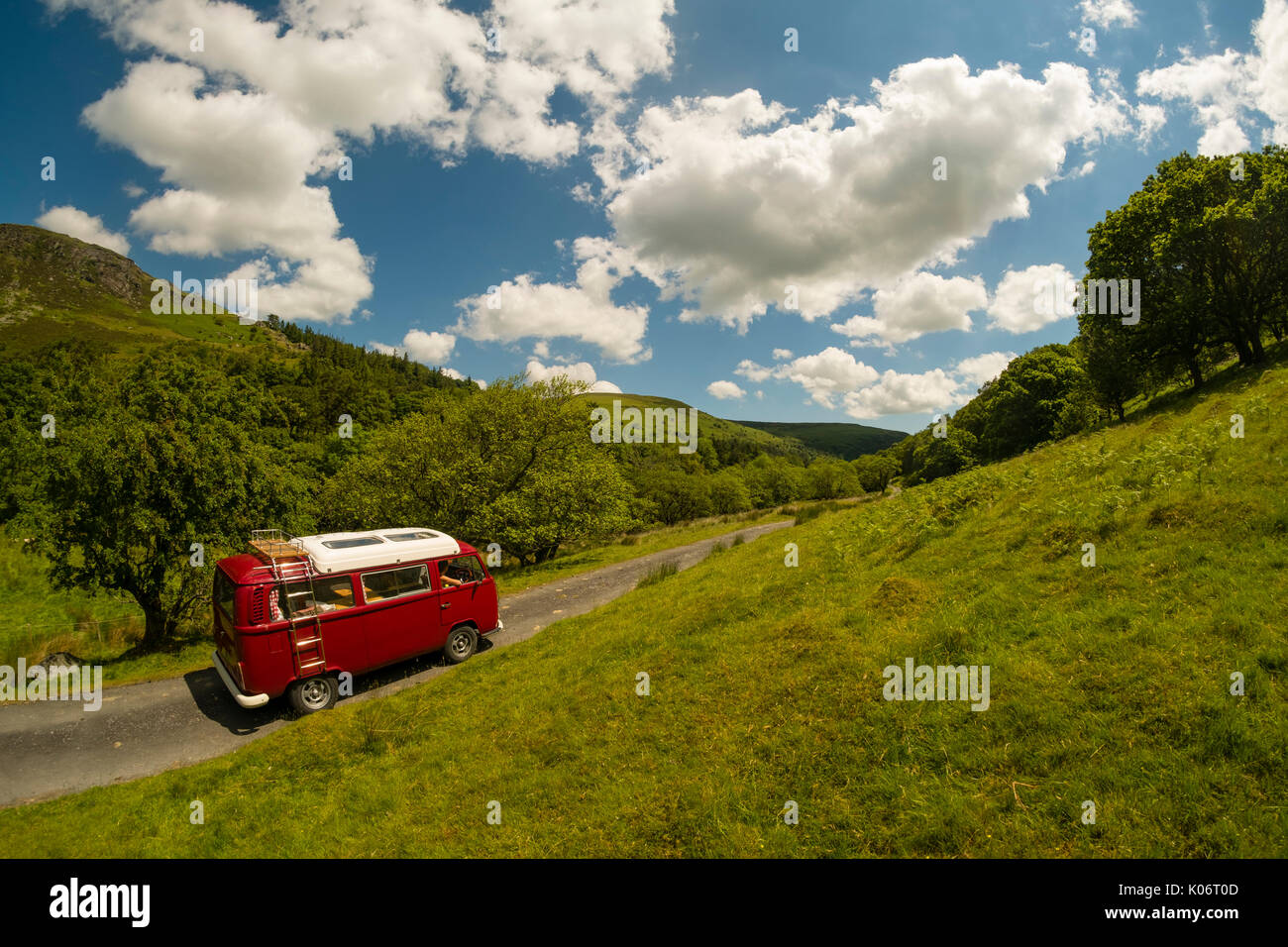 Sommer im Wye Valley: eine Frau mittleren Alters fahren Ihre klassische 1973 VW Typ 2 (T2) Erker roten Wohnmobil Urlaub entlang der malerischen Wye Valley in der Mitte von Wales an einem heißen Juli morgen. Powys Wales UK Stockfoto