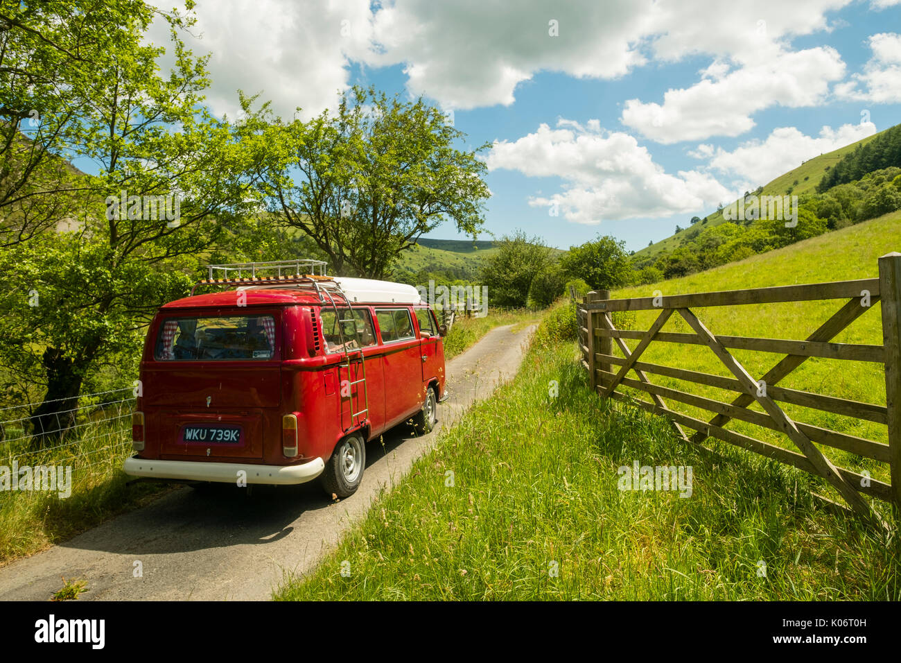 Sommer im Wye Valley: eine Frau mittleren Alters fahren Ihre klassische 1973 VW Typ 2 (T2) Erker roten Wohnmobil Urlaub entlang der malerischen Wye Valley in der Mitte von Wales an einem heißen Juli morgen. Powys Wales UK Stockfoto