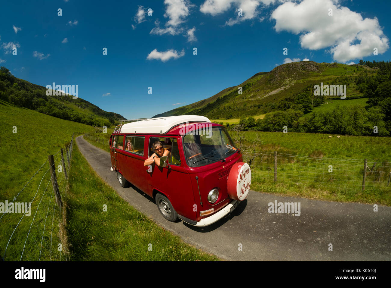 Sommer im Wye Valley: eine Frau mittleren Alters fahren Ihre klassische 1973 VW Typ 2 (T2) Erker roten Wohnmobil Urlaub entlang der malerischen Wye Valley in der Mitte von Wales an einem heißen Juli morgen. Powys Wales UK Stockfoto