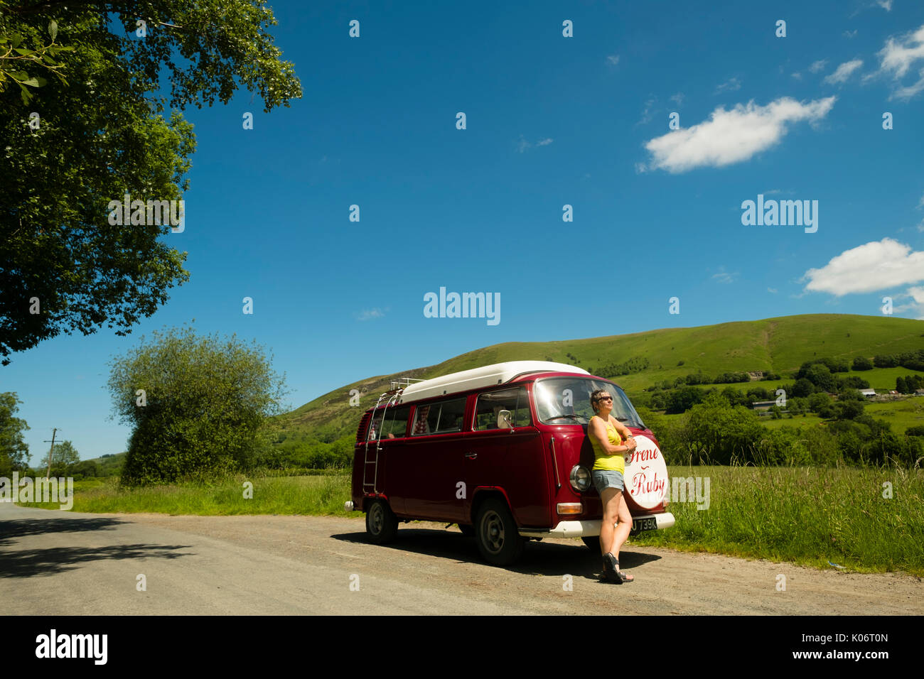 Sommer im Wye Valley: eine Frau mittleren Alters fahren Ihre klassische 1973 VW Typ 2 (T2) Erker roten Wohnmobil Urlaub entlang der malerischen Wye Valley in der Mitte von Wales an einem heißen Juli morgen. Powys Wales UK Stockfoto