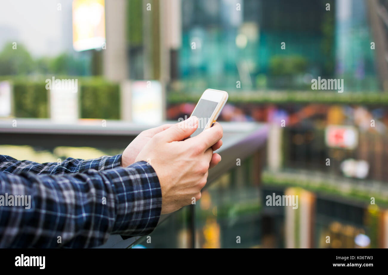 Männliche Hände mittels Smart Phone in der modernen Geschäftswelt Stockfoto