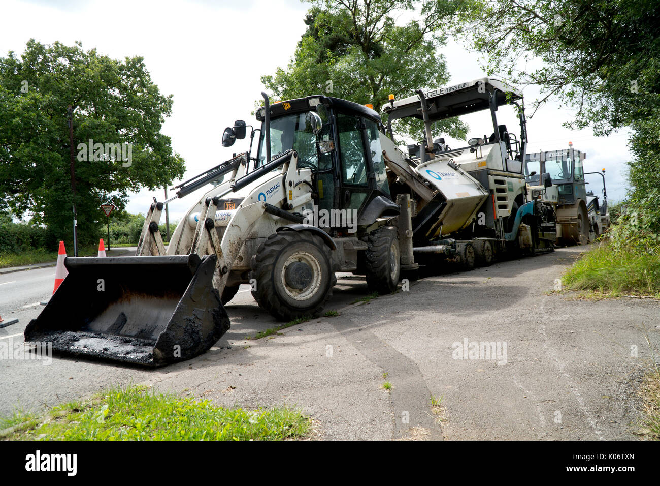 Road Repair Maschinen, Bagger, Walze und Asphalt zur Maschine in einen Feldweg geparkt. Stockfoto