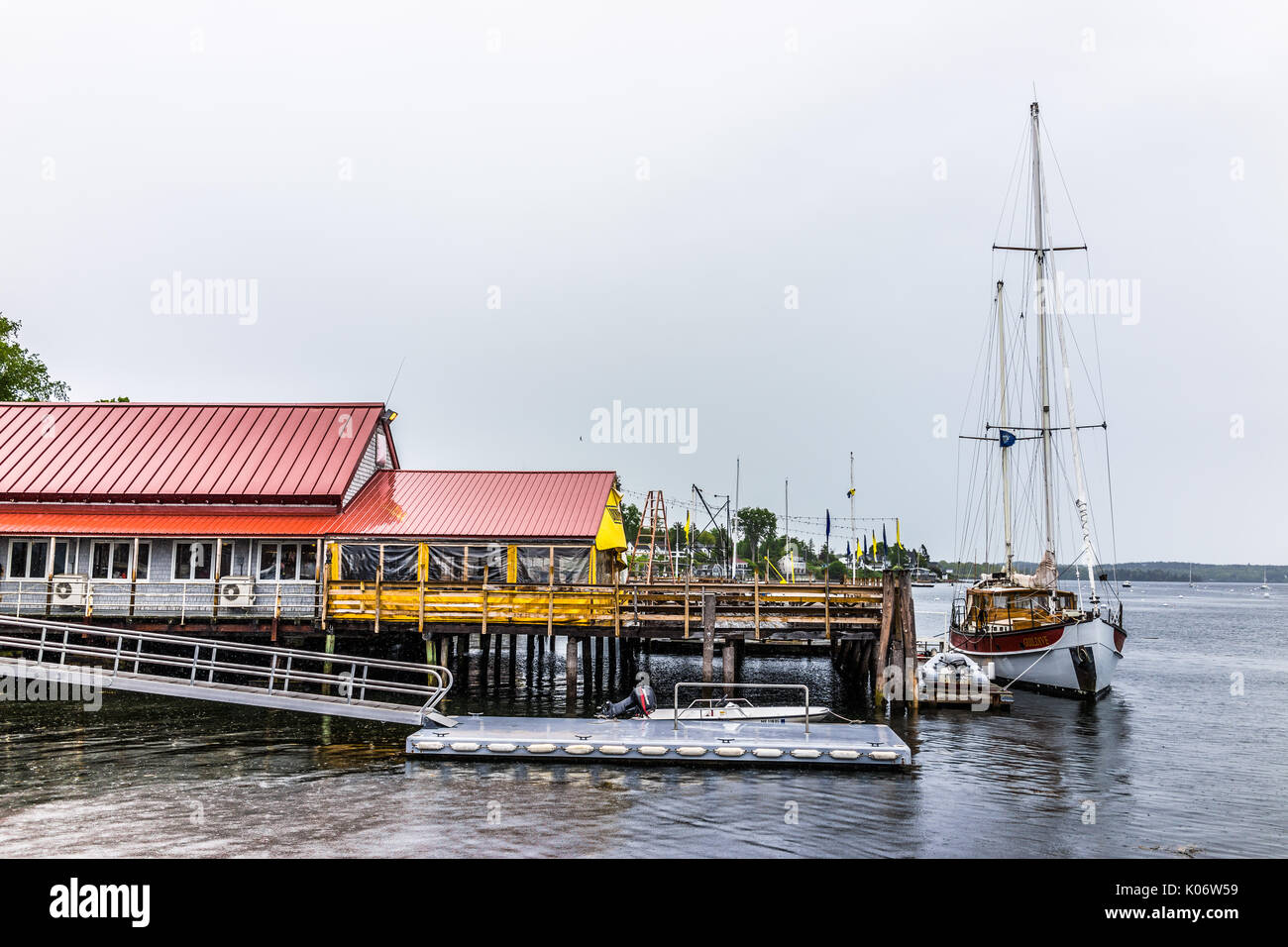 Castine, USA - Juni 9, 2017: leere Holz- Marina Hafen in einem kleinen Dorf in Maine bei Regen mit Booten und Waterfront Restaurant Gebäude Stockfoto