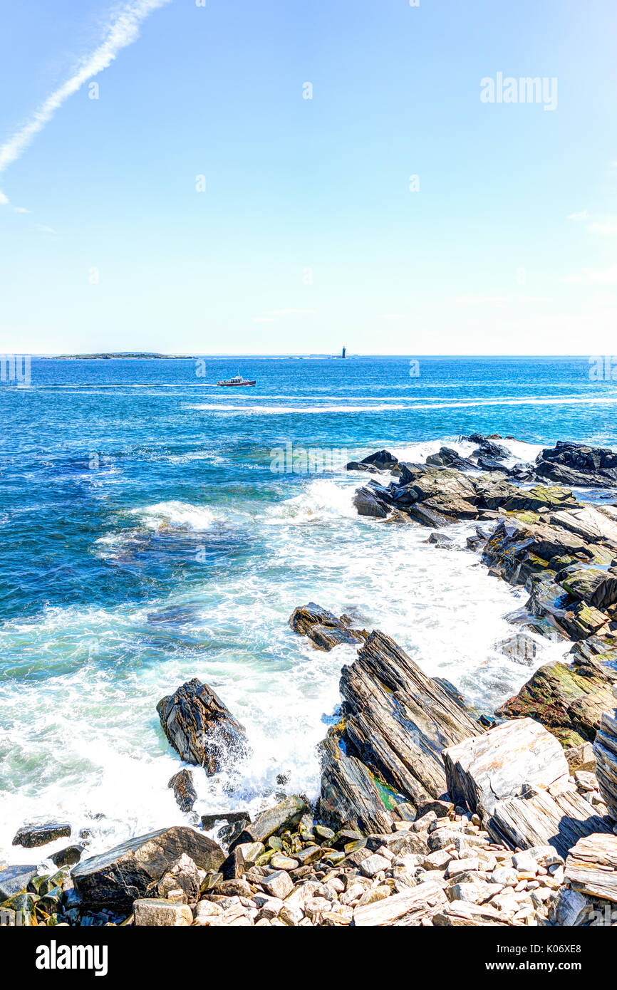 Cliff Felsen mit roten Boot durch Portland Head Lighthouse in Fort Williams Park in Cape Elizabeth, Maine im Sommer Tag Stockfoto