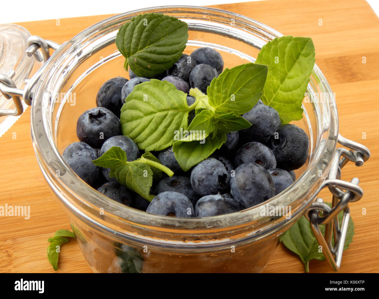 Blaubeeren in einem Glas auf einem Holzbrett Stockfoto